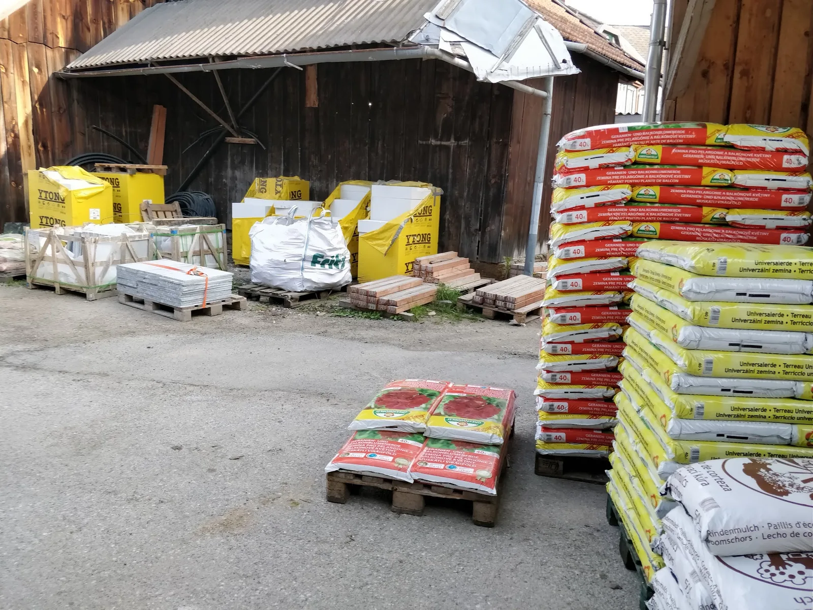 Paletten mit Baustoffen, Ziegeln, Erde und Big Bags im Hof von Paulnsteiner